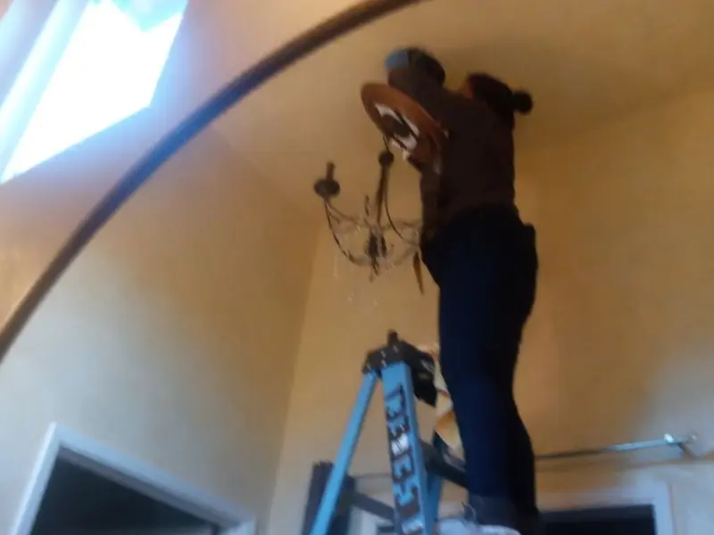 Electrician installing a chandelier in a Orangevale residence